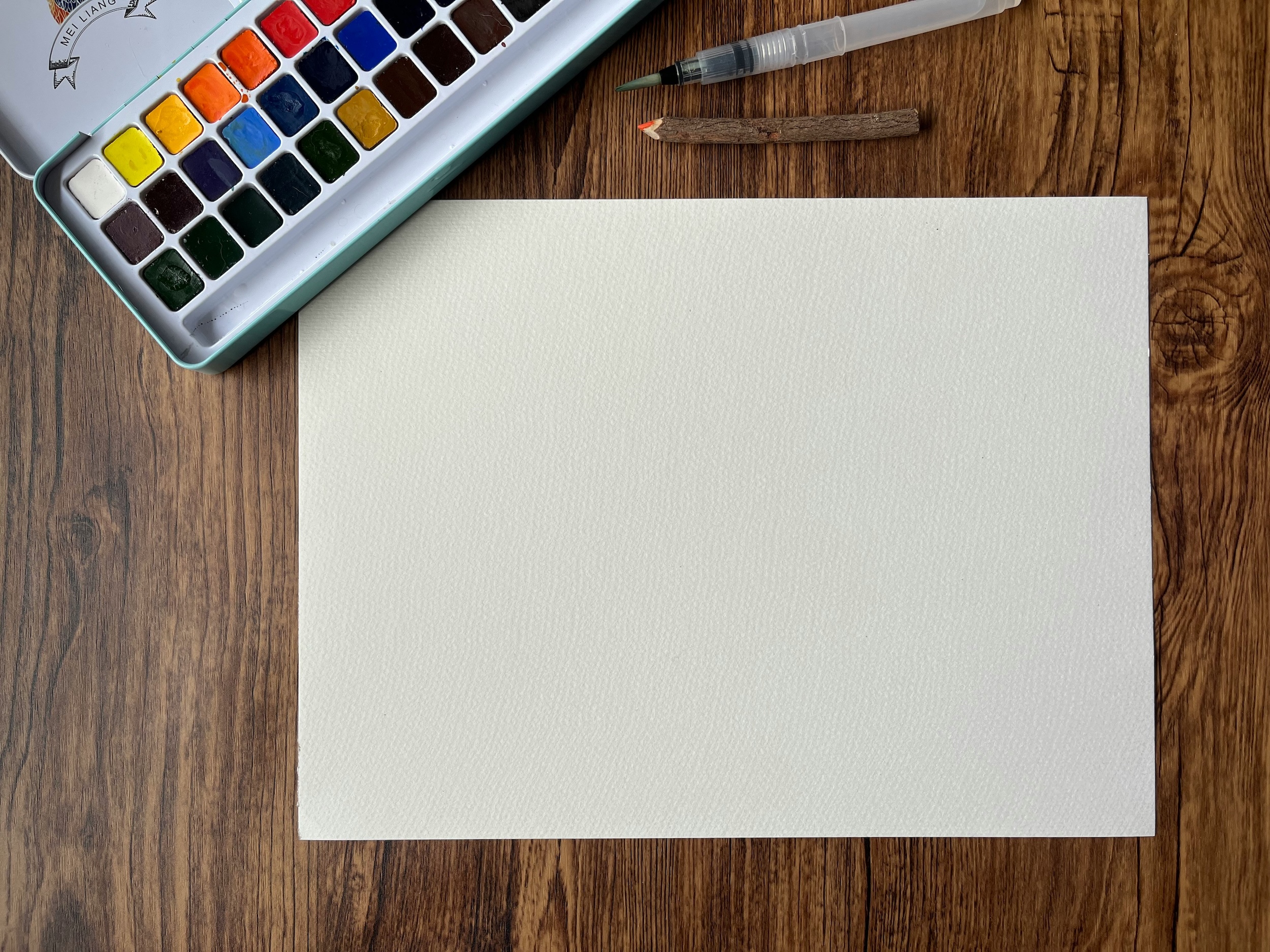 Foto von Jaz de Valle, Aquarellfarben und Papier auf Holztisch